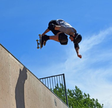 ST NEOTS, CAMBRIDGESHIRE, ENGLAND - JULY 03, 2022: Skateboarder performing grab stunt on Vert Ramp.