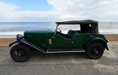 FELIXSTOWE, SUFFOLK, ENGLAND - MAYIS 05, 2019: Arka planda deniz kenarında park edilmiş eski Riley Otomobili.