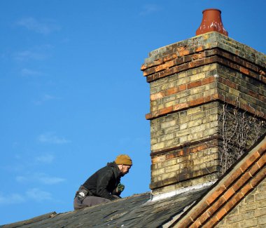 St. NEOTS, CAMBRIDGESHIRE, İngiltere - 18 HAZİRAN 2022: çatı tamiratı ve Viktorya Baca tamiratı yapan işçi.