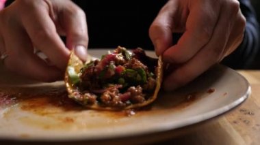 Meksika mutfağında lezzetli taco yiyen aç bir adam. Yakın plan.