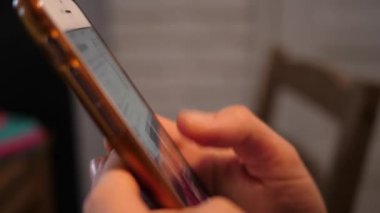 WROCLAW, POLAND - 11 Şubat 2022: Sosyal medyada akıllı telefon kaydırma ekranı kullanan yakın plan kadın