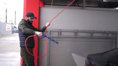 Arabasını temizleme köpüğü ile yıkayan bir adam. 