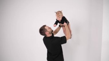 Genç baba siyah elbiseli küçük kızıyla oyun oynamayı seviyor.