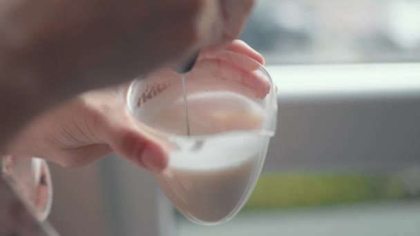 여자 손 은수 동식 카푸치노 토레를 손으로 쥐고 우유를 얼린다. 우유를 기본으로 한다. 홈 메이드 — 비디오