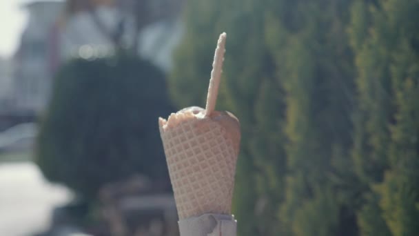 Wirujący rożek lodowy z ciasteczkami na wierzchu w słoneczny gorący dzień. — Wideo stockowe