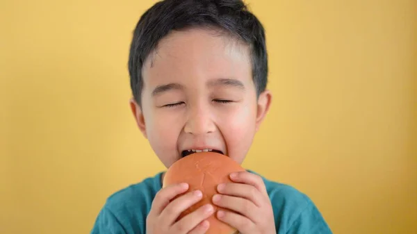 Netter Junge, der gerne in einen Burger beißt — Stockfoto