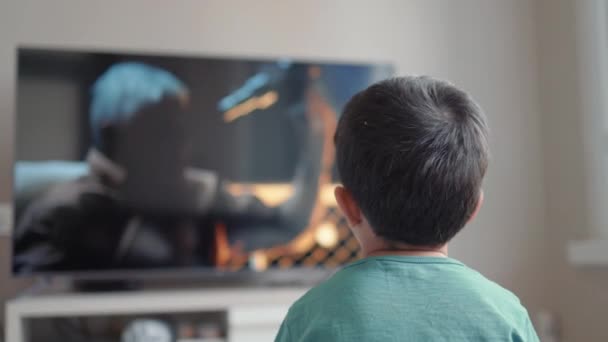 バックビューの小さな男の子見る映画上のテレビ-ホーム — ストック動画