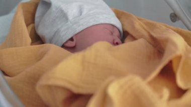 Yeni doğan bebek hastanede doğumdan sonra karyolada uyur.