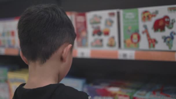 Asian preschooler choosing toys in supermarket — Vídeos de Stock