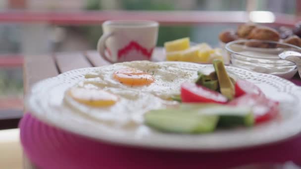 Healthy breakfast with fried eggs, vegetables, fruit, dairy and nuts on table — Vídeo de Stock