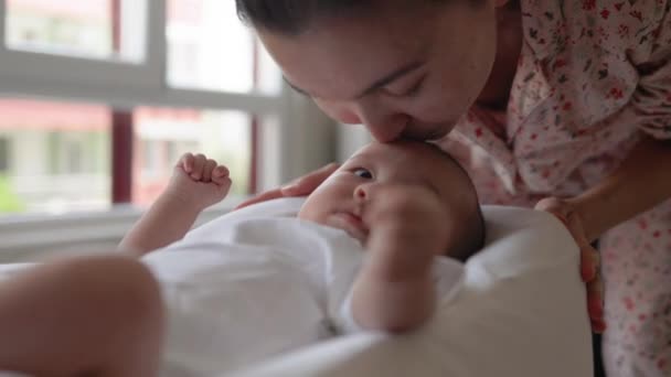 Mamma kysser sitt babyhuvud. Lyckligt moderskap, föräldraskap — Stockvideo