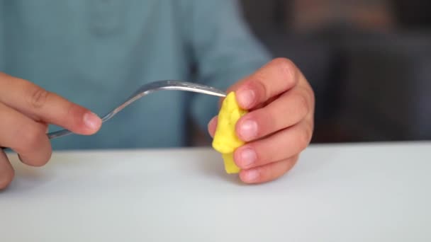 Close-up view of little hands sculpts a figure using fork — Stok video