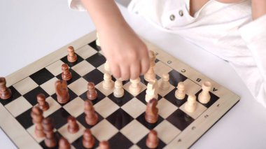 Satranç tahtasındaki satranç figürünü hareket ettiren küçük ellerin yakın plan görüntüsü