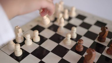 Satranç tahtasındaki satranç figürünü hareket ettiren küçük ellerin yakın plan görüntüsü