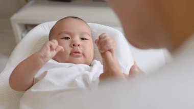 Anne bebeğinin elini tutuyor ve onunla konuşuyor. Mutlu annelik, ebeveynlik