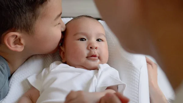 Brother kisses baby while mother holding babys hand. Happy motherhood, parenthood — 스톡 사진