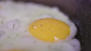 Yumurta kırılır ve tavaya akar. Sağlıklı kahvaltı konsepti. Görüntüyü kapat