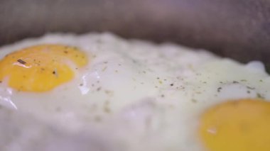 Yumurta kırılır ve tavaya akar. Sağlıklı kahvaltı konsepti. Görüntüyü kapat