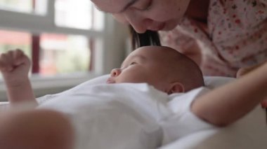 Anne bebeğinin başını öpüyor. Mutlu annelik, ebeveynlik