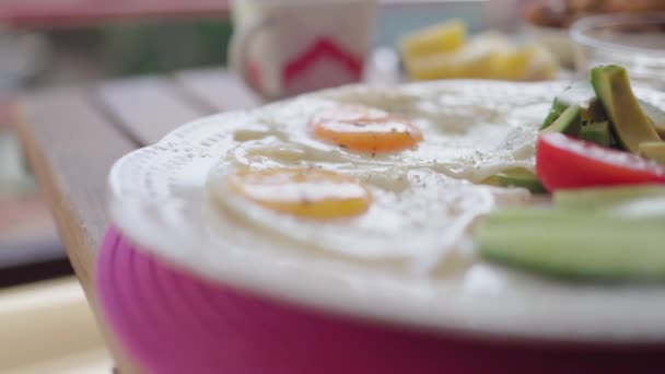 Healthy breakfast with fried eggs, vegetables, fruit, dairy and nuts on table — Vídeo de Stock