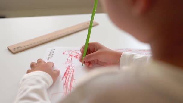 Vista trasera del dibujo preescolar con pluma roja sobre un papel blanco. — Vídeo de stock