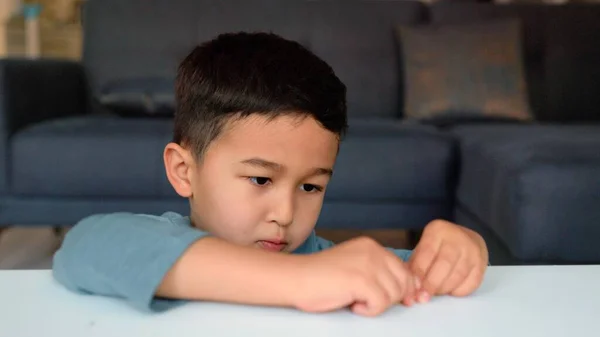 Little asian preschooler engaged in creativity. Boy sculpts a figure on a table — Stockfoto