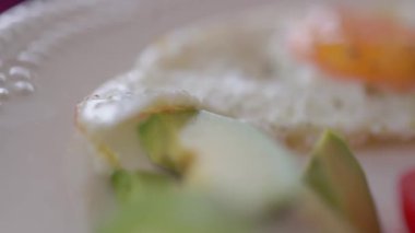 Sağlıklı kahvaltı tabağı, kızarmış yumurta, domates, salatalık ve avokado. Yakın görünüm