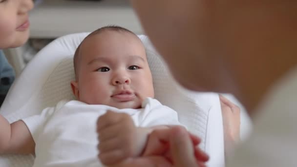 Bruder küsst Baby, während Mutter Babys Hand hält. Glückliche Mutterschaft, Elternschaft — Stockvideo