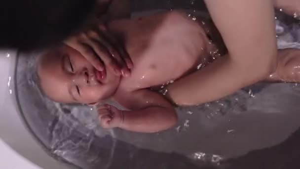 Annenin bebeklerin kafasını ve yüzünü yıkamasının en iyi görüntüsü. — Stok video