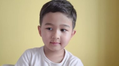 Neşeli anaokulu öğrencisi gülümsüyor ve arka planda başparmak kaldırıyor