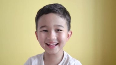 Tatlı çocuk kameraya bakıyor ve arka planda gülüyor.