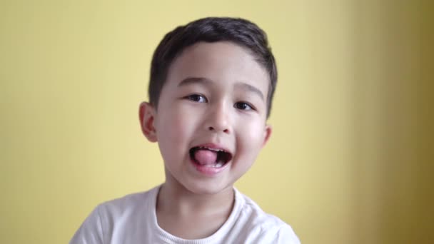 Munter førskole smilende og viser tommelfingre op på farve baggrund – Stock-video