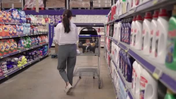 Morena mujer en blanco tomar productos y ponerlo en carro — Vídeos de Stock
