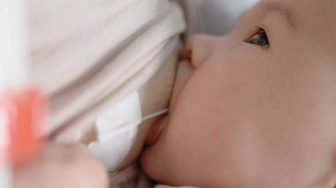 Anne SNS sistemli bebeği emziriyor. Görüntüyü kapat