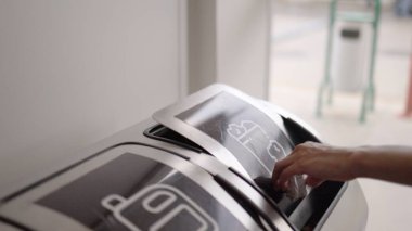 Kadınlar geri dönüşüm için konteynıra kağıt atıyorlar. Gobal kirliliği sorunu.