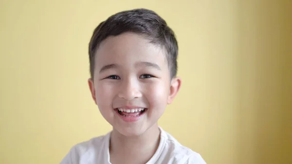 Netter Junge schaut in die Kamera und lacht auf farbigem Hintergrund — Stockfoto