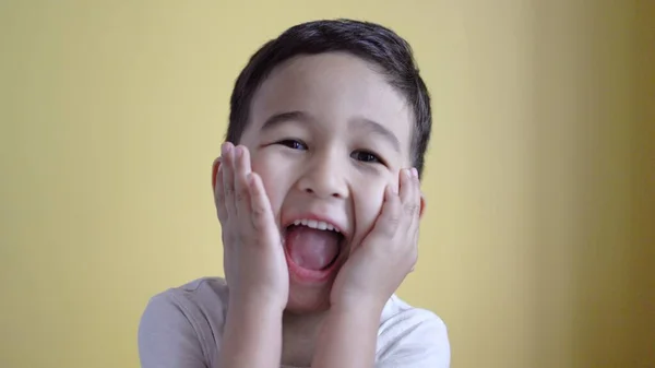 Emotionaler Junge überrascht und lächelt auf farbigem Hintergrund — Stockfoto