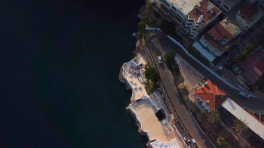 Gün batımında deniz kenarında kıvrımlı yolu olan adanın en üst hava manzarası. Yüksek kalite 4k görüntü