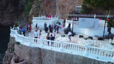 Düğünden sonra kayalıklarda insanların yan görüntüsü. Damat ve gelin tebrikleri kabul etti. Yüksek kalite 4k görüntü