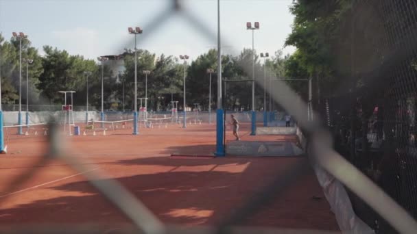 Folk Spelar Tennis Tennisbanan Utsikt Genom Nätet Avstånd Högkvalitativ Film — Stockvideo