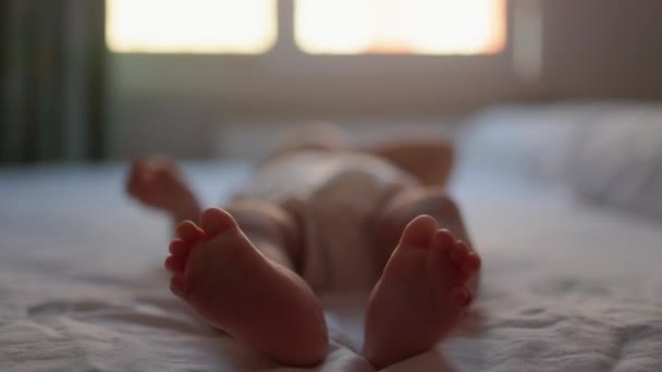 Das Baby Weiß Liegt Auf Dem Bett Und Zuckt Mit — Stockvideo