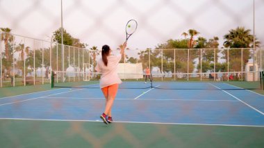 Tenis oyuncusu topa arkasından raketle vuruyor. Ağır çekim. Yüksek kalite 4k görüntü
