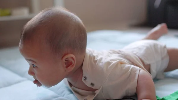 Der Kleine Junge Liegt Auf Dem Bauch Und Versucht Seinen — Stockfoto