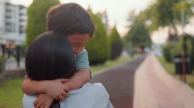 Sevimli anaokulu çocuğu ara sokakta annesine sarılıyor. Yüksek kalite 4k görüntü