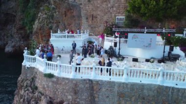 Düğünden sonra kayalıklarda insanların yan görüntüsü. Damat ve gelin tebrikleri kabul etti. Yüksek kalite 4k görüntü