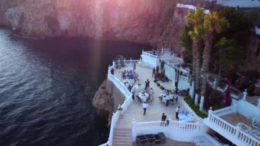 Aerial view of people after wedding ceremony on the cliff. High quality 4k footage