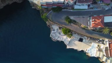 Gün batımında deniz kenarında kıvrımlı yolu olan adanın en üst hava manzarası. Yüksek kalite 4k görüntü