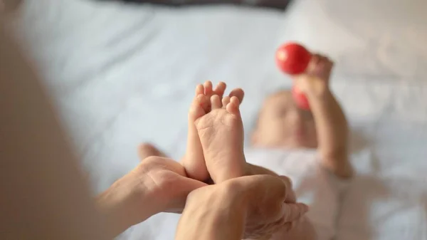 Mother Holds Babys Legs Infant Child Takes Toy High Quality — Φωτογραφία Αρχείου