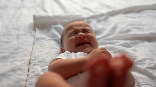 Little baby is crying on bed. High quality 4k footage