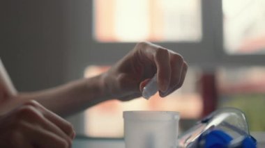 Kadın eller bir ilaç açıyor ve astım spreyine dökülüyor. Yüksek kalite 4k görüntü